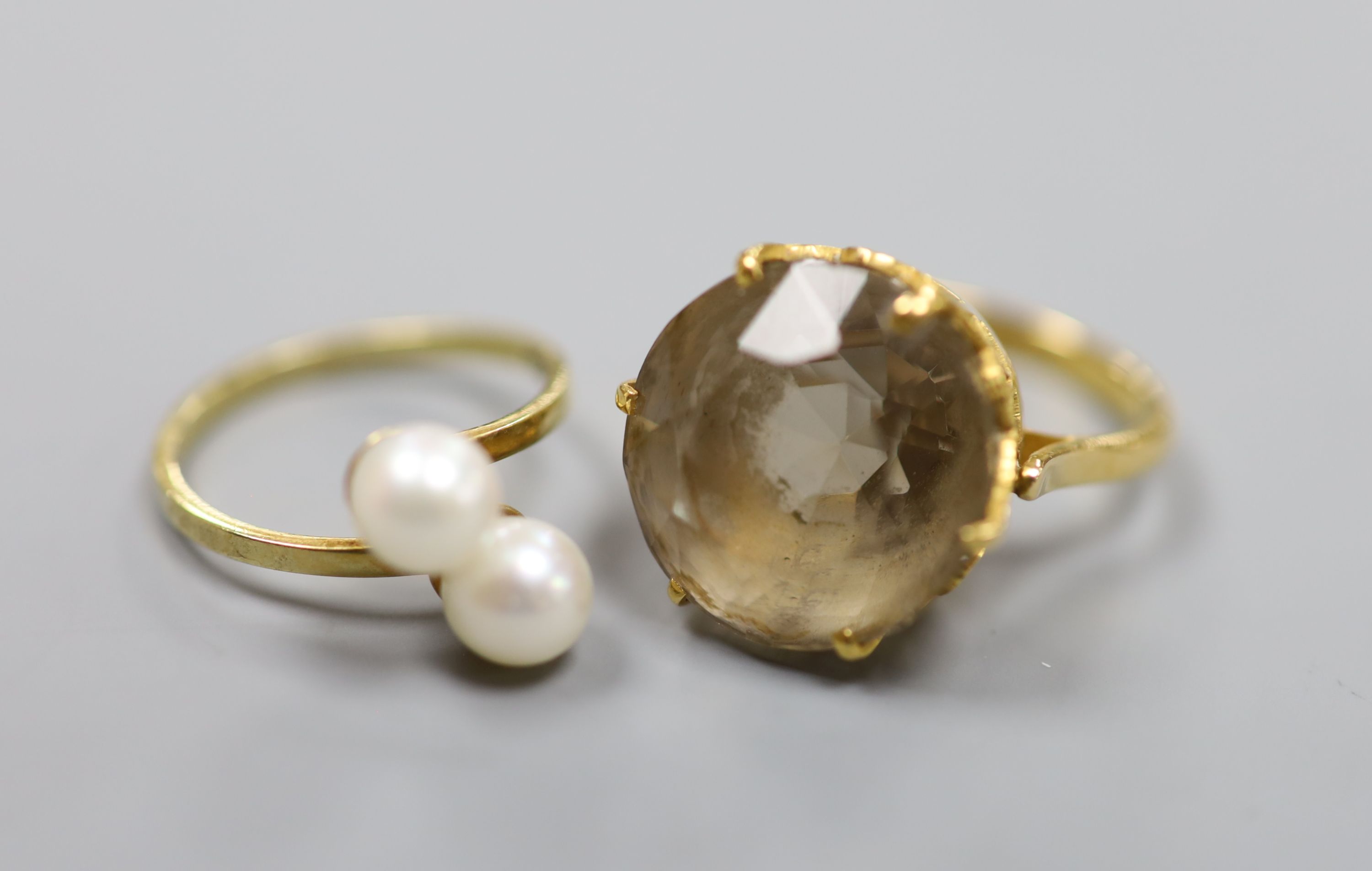 A yellow metal and smoky quartz dress ring, gross 8.2 grams and a 585 and two stone cultured pearl set crossover ring, gross 2.3 grams.